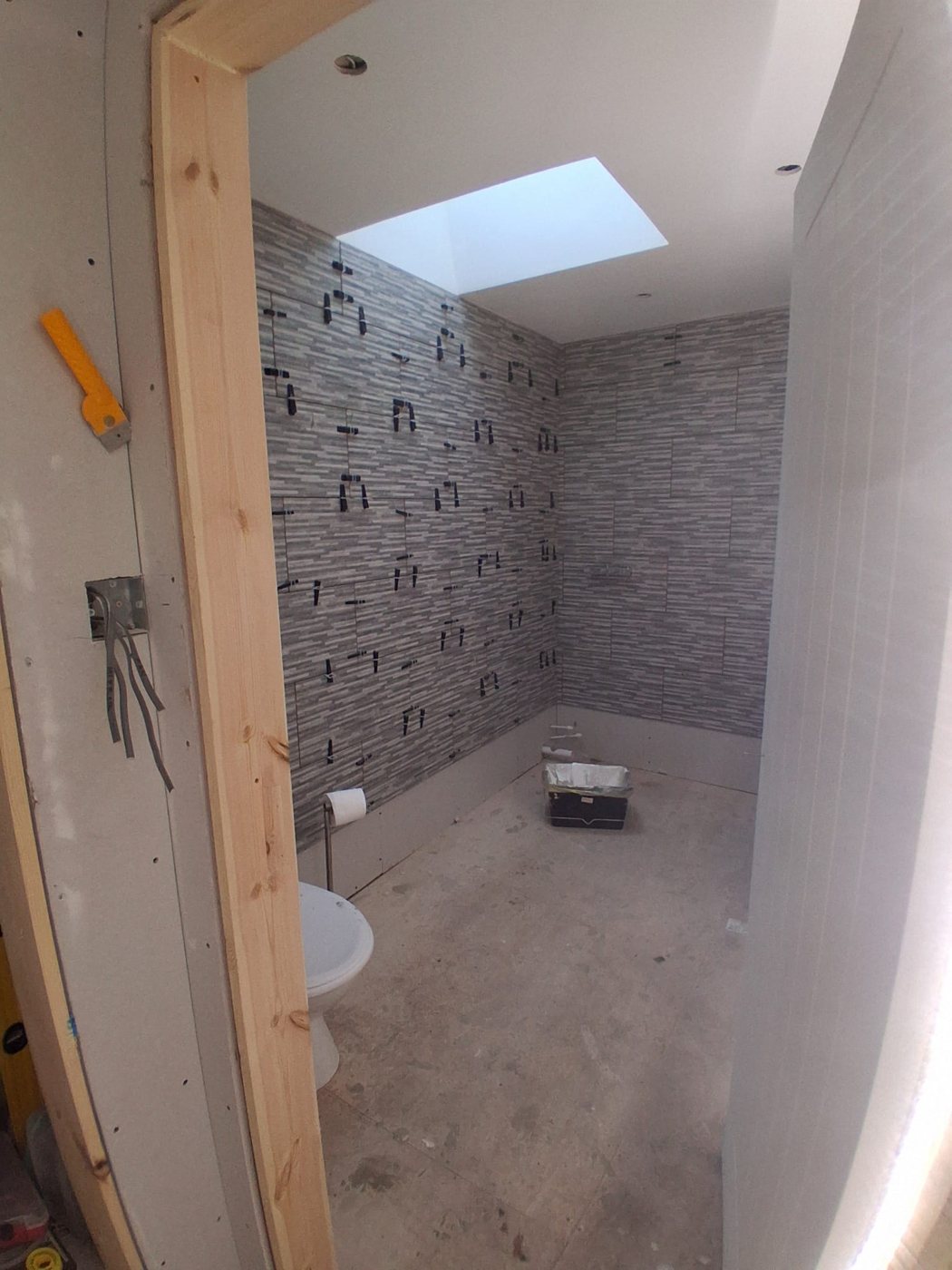 View through a new timber door lining into the room during wall tiling