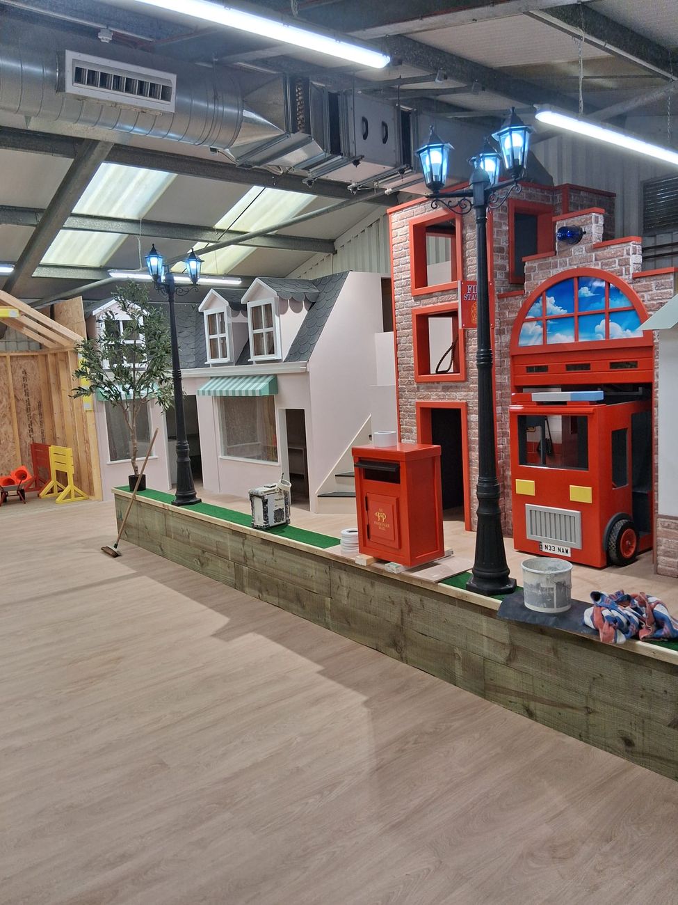 Finished indoor play street with a brick-effect fire station, a red fire engine play unit and cast-style lamp posts