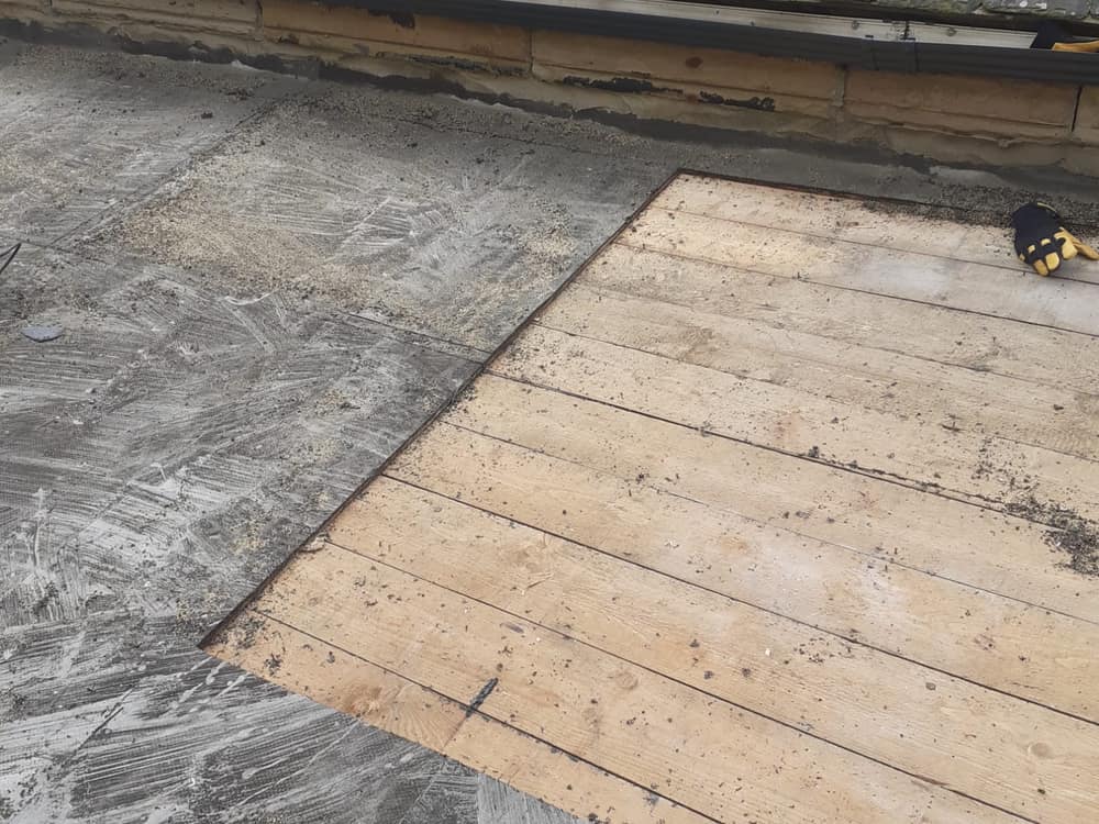 Slate roof edge meeting a floated flat surface and timber boarding
