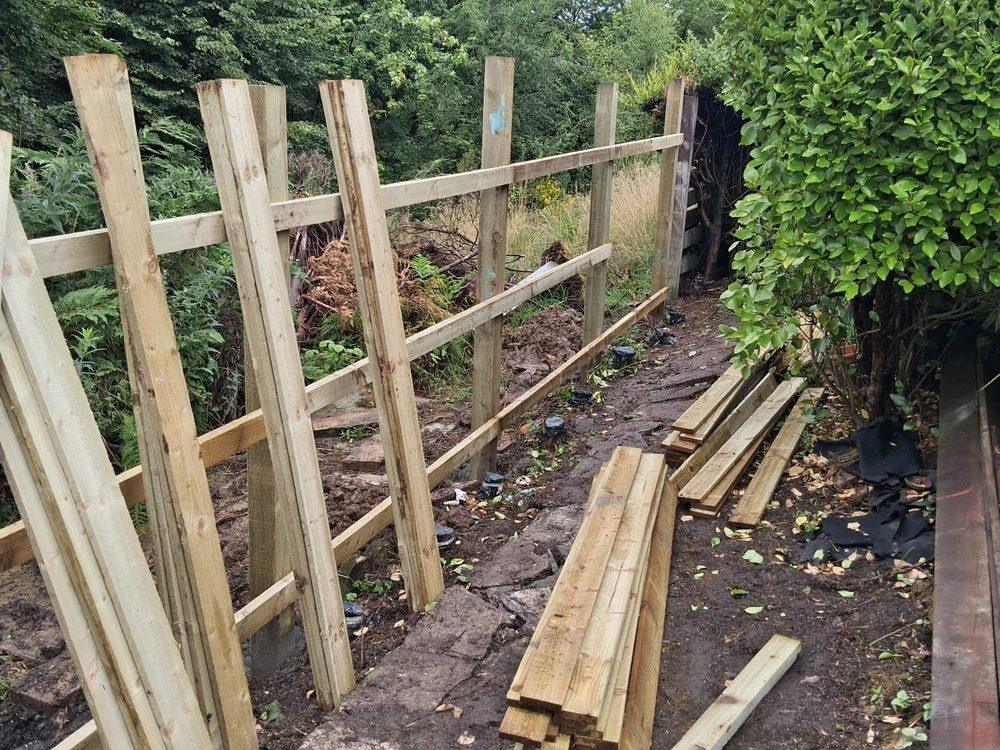 New fence posts and arris rails set along a garden boundary