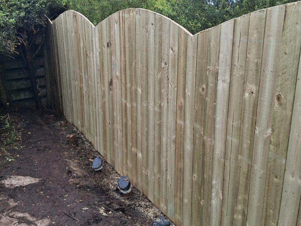 Finished 6ft fence with arched board tops turning the corner of a rear garden