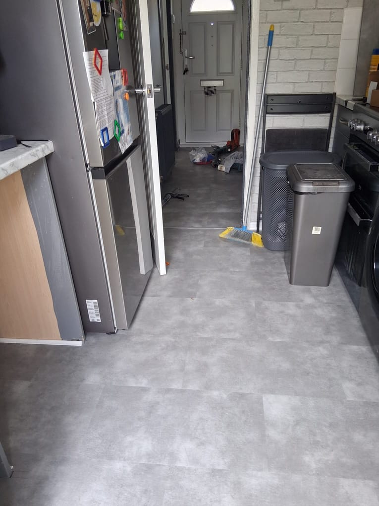Completed grey vinyl tile floor running from the kitchen through to the hallway